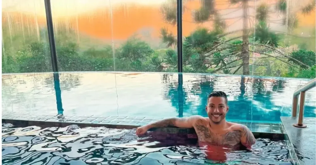 Felipe Santos relaxando na piscina coberta da pousada em Porto Seguro ao entardecer